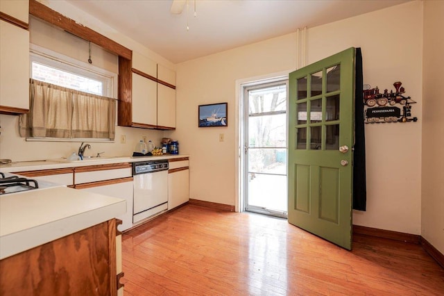 kitchen featuring a wealth of natural light, light wood-type flooring, light countertops, and white dishwasher