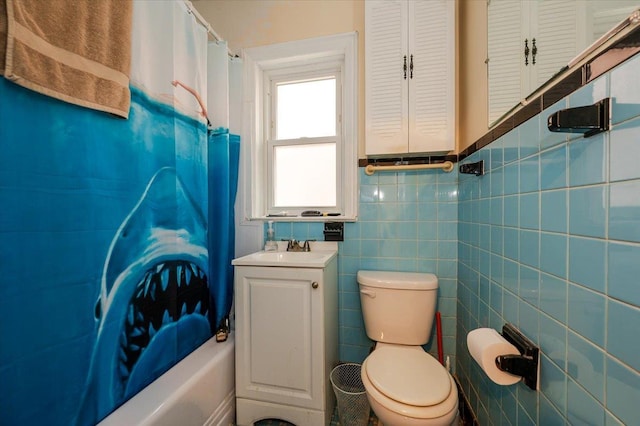 full bath featuring vanity, tile walls, and toilet