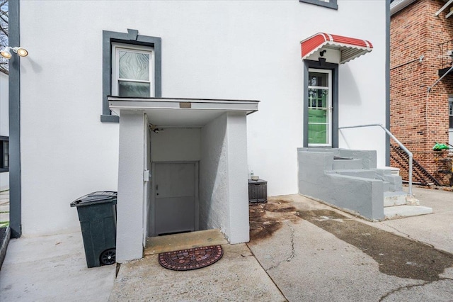 entrance to property featuring stucco siding