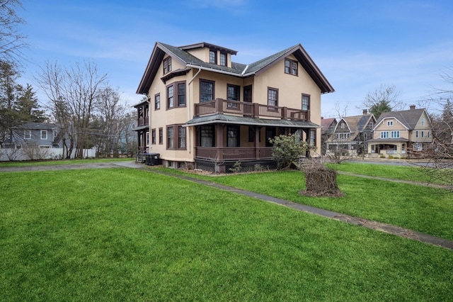 back of property with a lawn and stucco siding