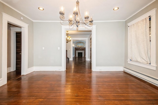 spare room with crown molding, wood finished floors, a baseboard radiator, and a chandelier