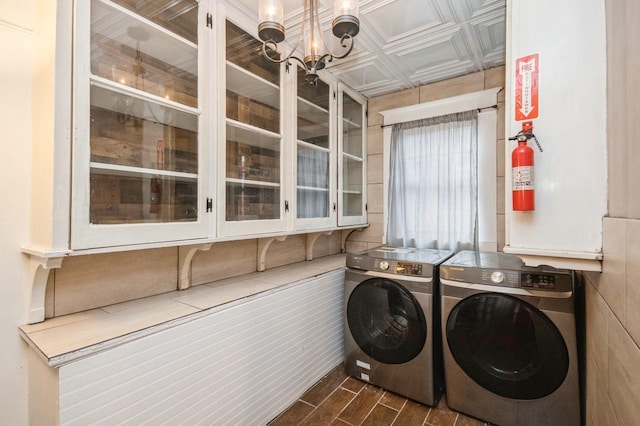 laundry room featuring wood tiled floor, laundry area, a notable chandelier, washer and dryer, and an ornate ceiling