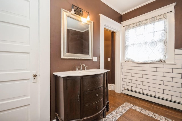 bathroom featuring vanity, crown molding, wood finish floors, and a baseboard radiator