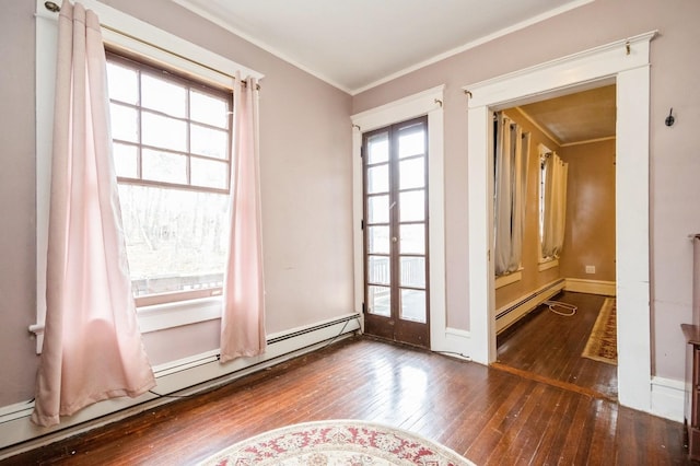 unfurnished room with a baseboard heating unit, baseboards, crown molding, and hardwood / wood-style flooring