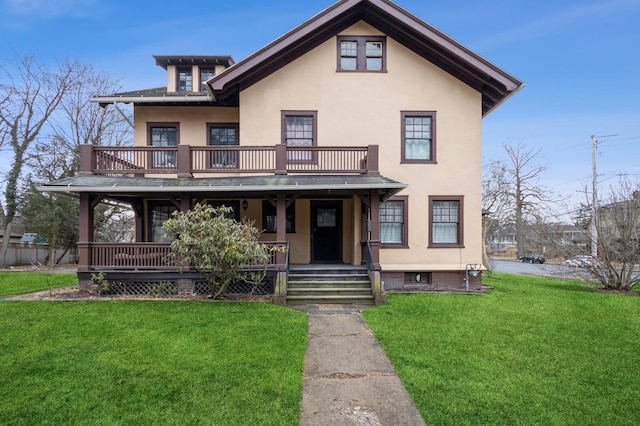 view of front of house with a front lawn, a balcony, covered porch, and stucco siding