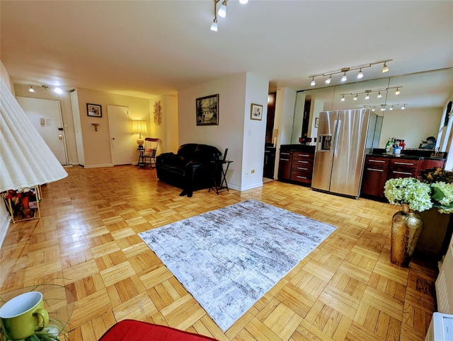 living area featuring rail lighting and baseboards