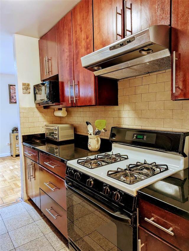 kitchen featuring dark brown cabinets, gas range oven, black microwave, under cabinet range hood, and backsplash