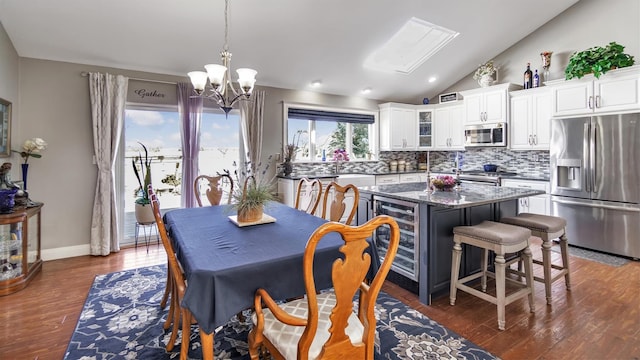 dining space featuring baseboards, wine cooler, a chandelier, lofted ceiling, and dark wood-style floors