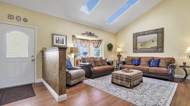 living area featuring vaulted ceiling, wood finished floors, and baseboards