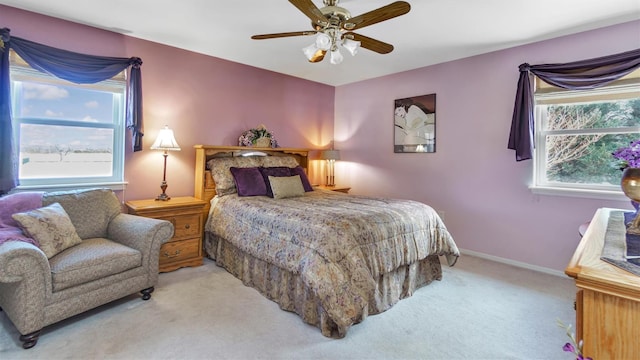 bedroom with carpet flooring, multiple windows, baseboards, and ceiling fan