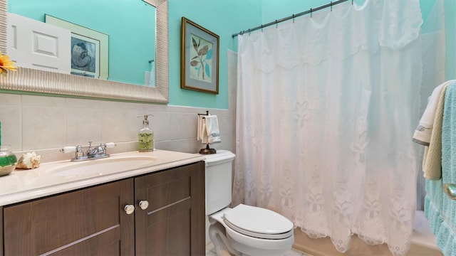 full bath with vanity, toilet, tile walls, and shower / bath combo