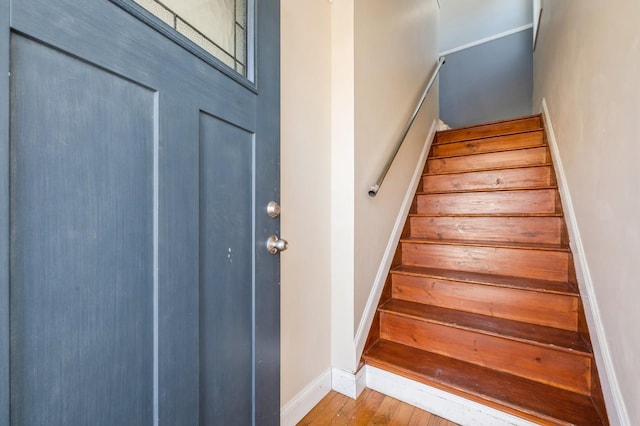 staircase with baseboards and wood finished floors