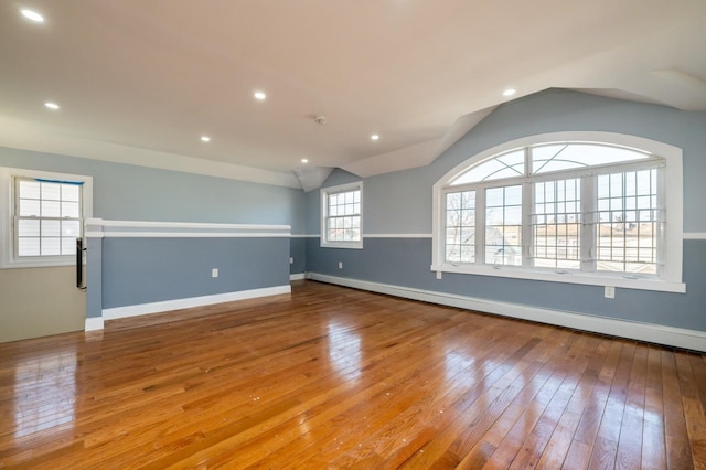 unfurnished room featuring baseboards, vaulted ceiling, recessed lighting, hardwood / wood-style flooring, and a baseboard radiator