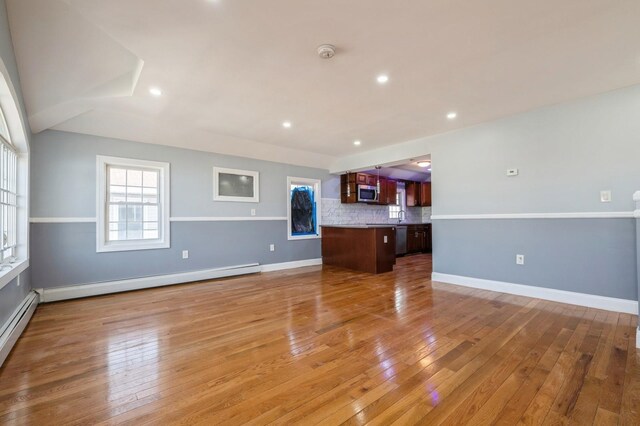 unfurnished living room featuring light wood-style flooring, recessed lighting, baseboards, and a baseboard radiator