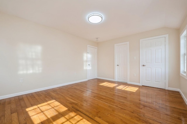 unfurnished room with baseboards and hardwood / wood-style flooring