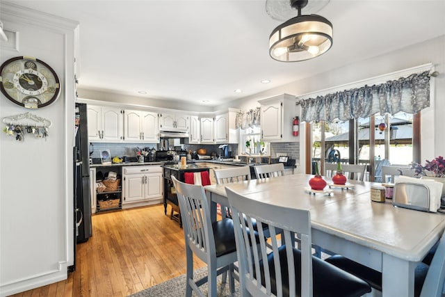 kitchen with white cabinetry, decorative backsplash, a healthy amount of sunlight, and light wood-type flooring