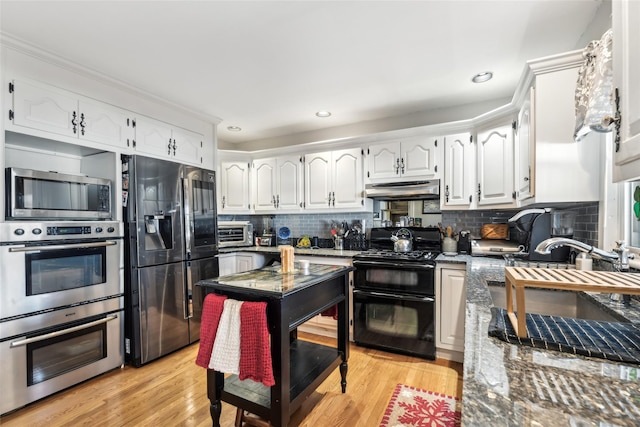 kitchen featuring under cabinet range hood, stainless steel appliances, light wood-style flooring, and white cabinetry