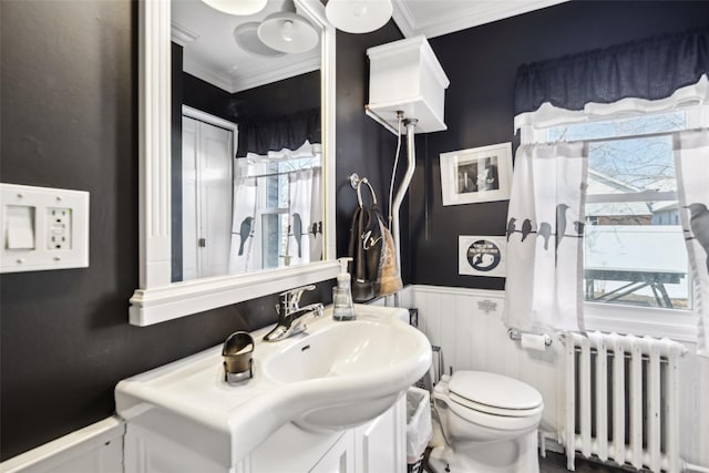 bathroom with a wainscoted wall, toilet, radiator heating unit, ornamental molding, and vanity