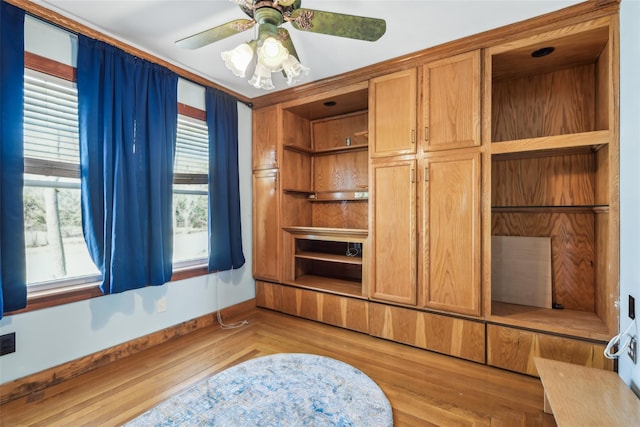 interior space with a ceiling fan, wood finished floors, and baseboards