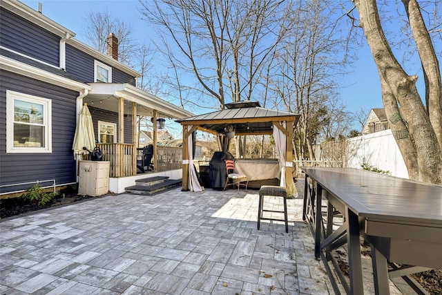 view of patio featuring a gazebo, a jacuzzi, and fence