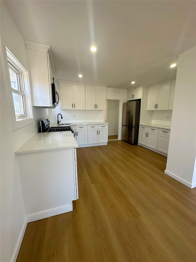 kitchen featuring white cabinets, light wood-type flooring, and appliances with stainless steel finishes