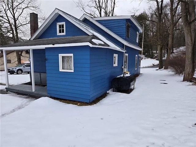 snow covered property featuring a chimney