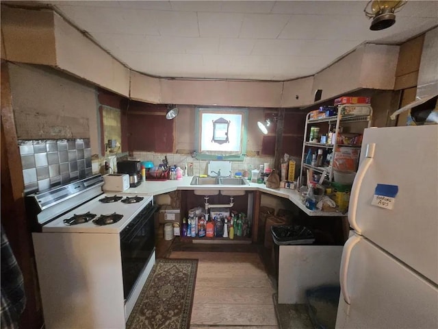 kitchen with backsplash, white appliances, light countertops, and a sink