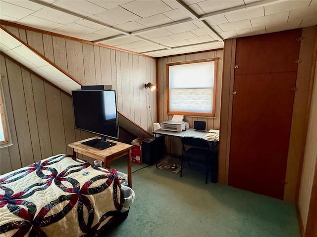 carpeted bedroom featuring wood walls