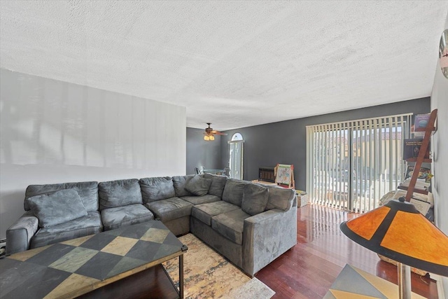 living area with a textured ceiling, wood finished floors, and ceiling fan