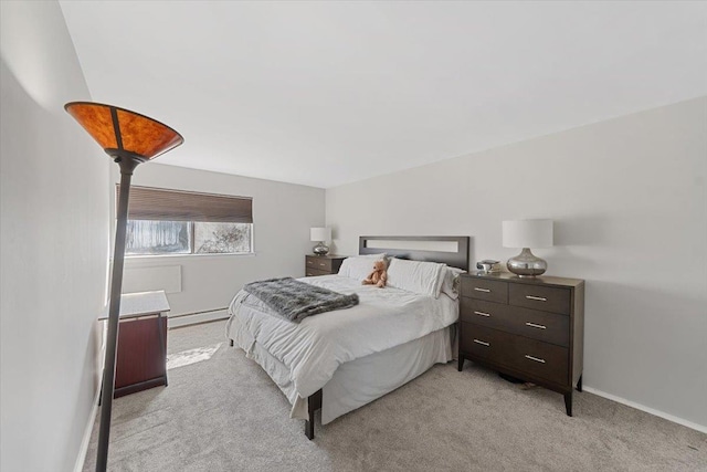 bedroom with baseboards, baseboard heating, and light carpet