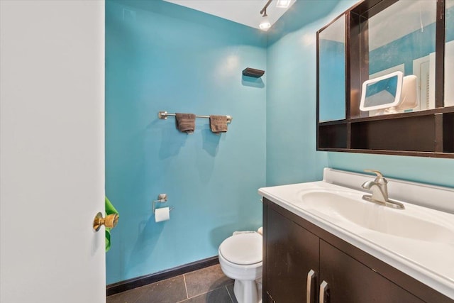 bathroom with vanity, toilet, baseboards, and tile patterned flooring