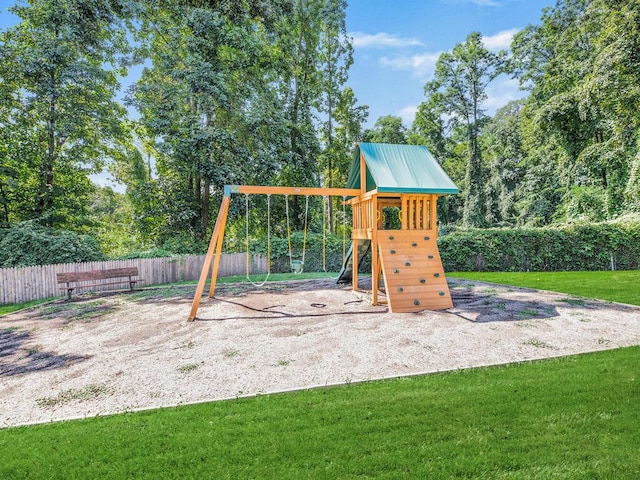 community play area with a lawn and fence