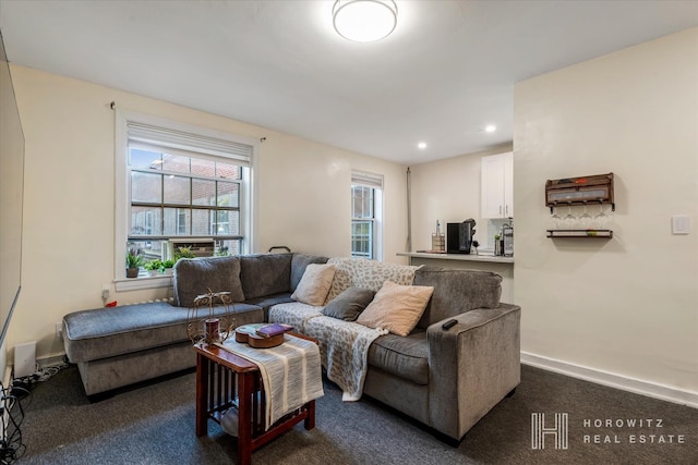 living area featuring recessed lighting, baseboards, and dark colored carpet