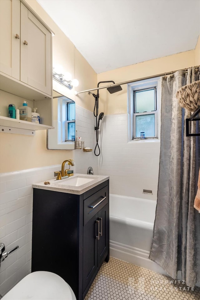 full bath with shower / tub combo with curtain, toilet, tile walls, tile patterned flooring, and vanity