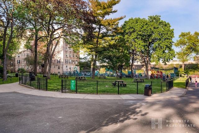 view of home's community with a lawn and fence