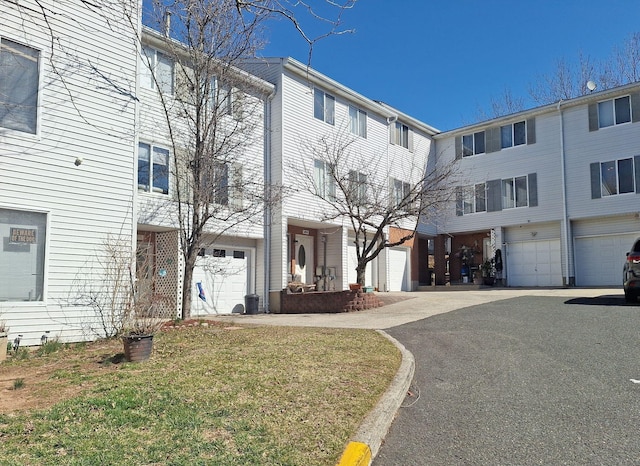 multi unit property featuring driveway and an attached garage