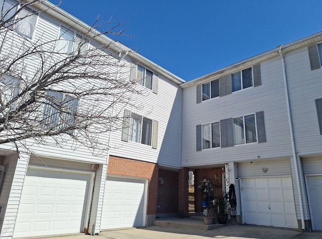 view of property with an attached garage and brick siding