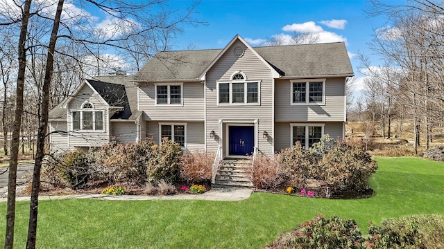 view of front of house with a front yard and roof with shingles