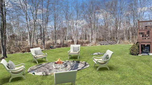 view of yard with a wooden deck and a fire pit