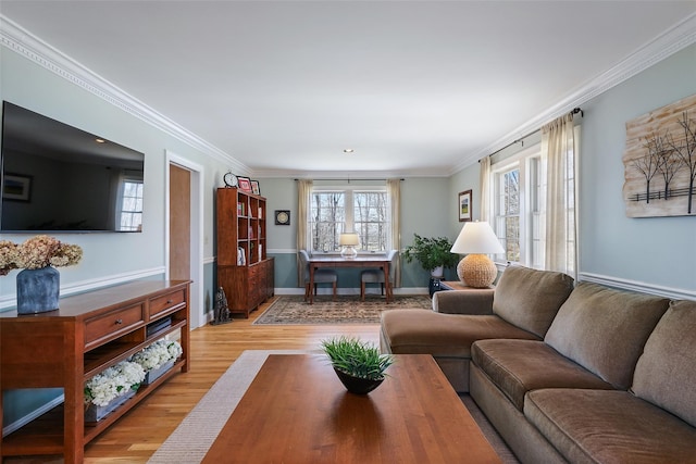 living area with light wood-style flooring, baseboards, and ornamental molding