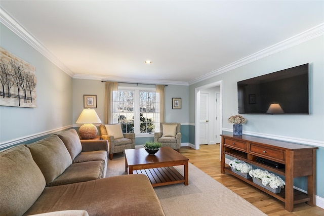 living area with wood finished floors, baseboards, and ornamental molding