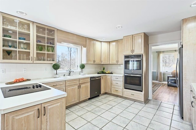 kitchen with light countertops, appliances with stainless steel finishes, light brown cabinets, and light tile patterned floors