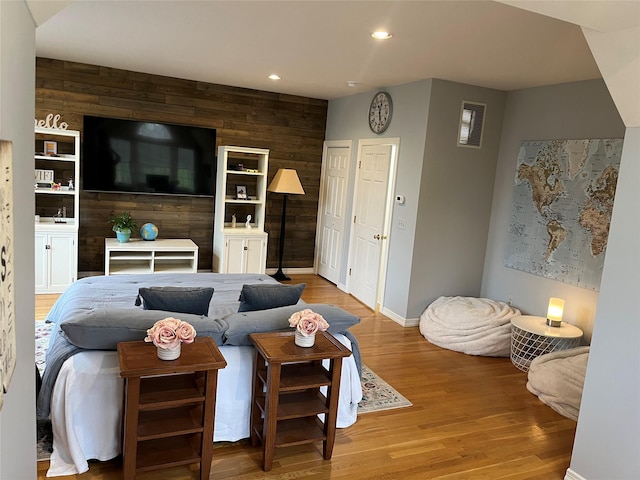 living area with wood finished floors, wooden walls, baseboards, and recessed lighting