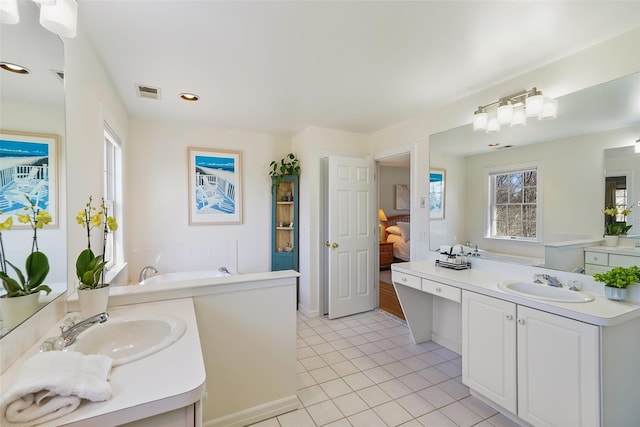 ensuite bathroom with tile patterned floors, ensuite bath, visible vents, and a sink