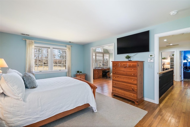 bedroom featuring wood finished floors, baseboards, and visible vents