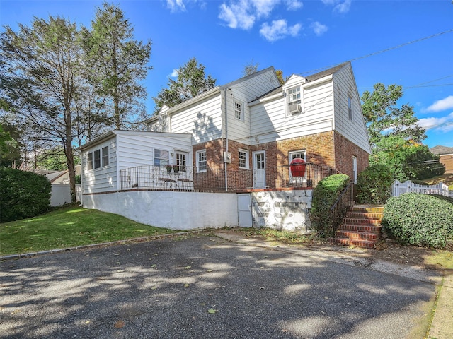 view of front of property with a front yard, fence, and brick siding