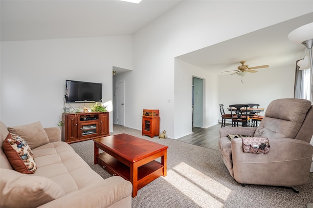 living area with baseboards, ceiling fan, high vaulted ceiling, and carpet