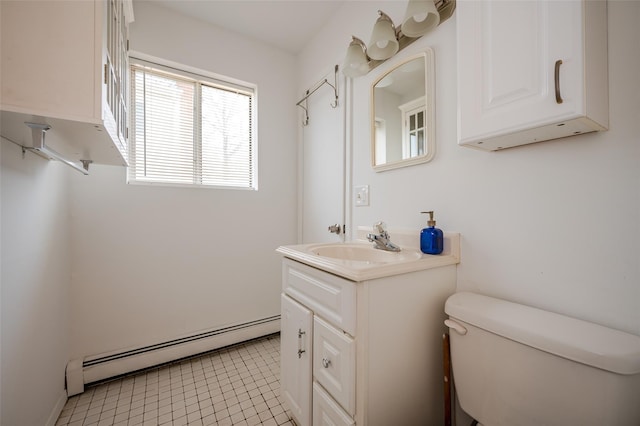 half bath featuring tile patterned floors, toilet, vanity, and a baseboard radiator