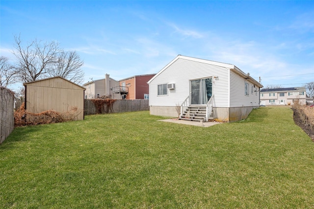 rear view of house with fence, entry steps, a lawn, an outdoor structure, and a wall mounted AC