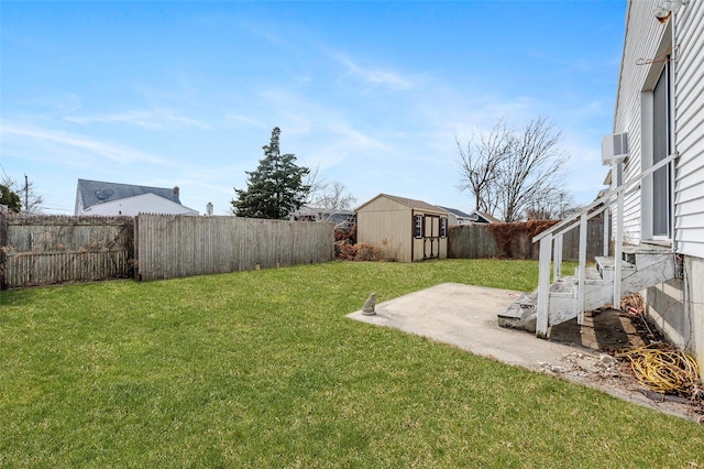 view of yard featuring a storage shed, an outdoor structure, and a fenced backyard